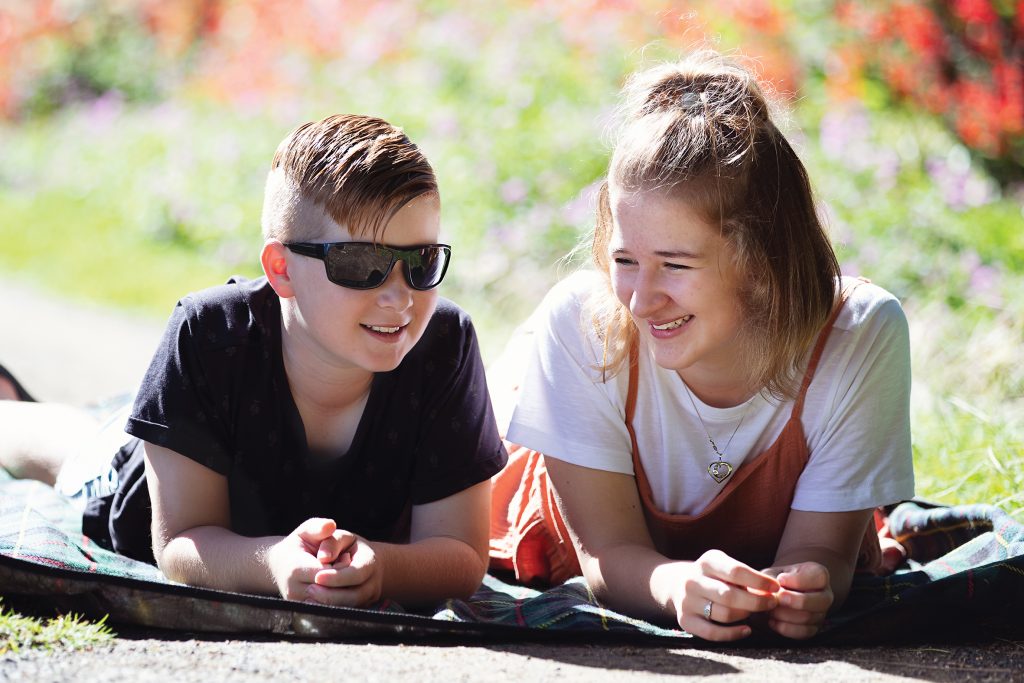 Two people smiling, one has vision impairment.